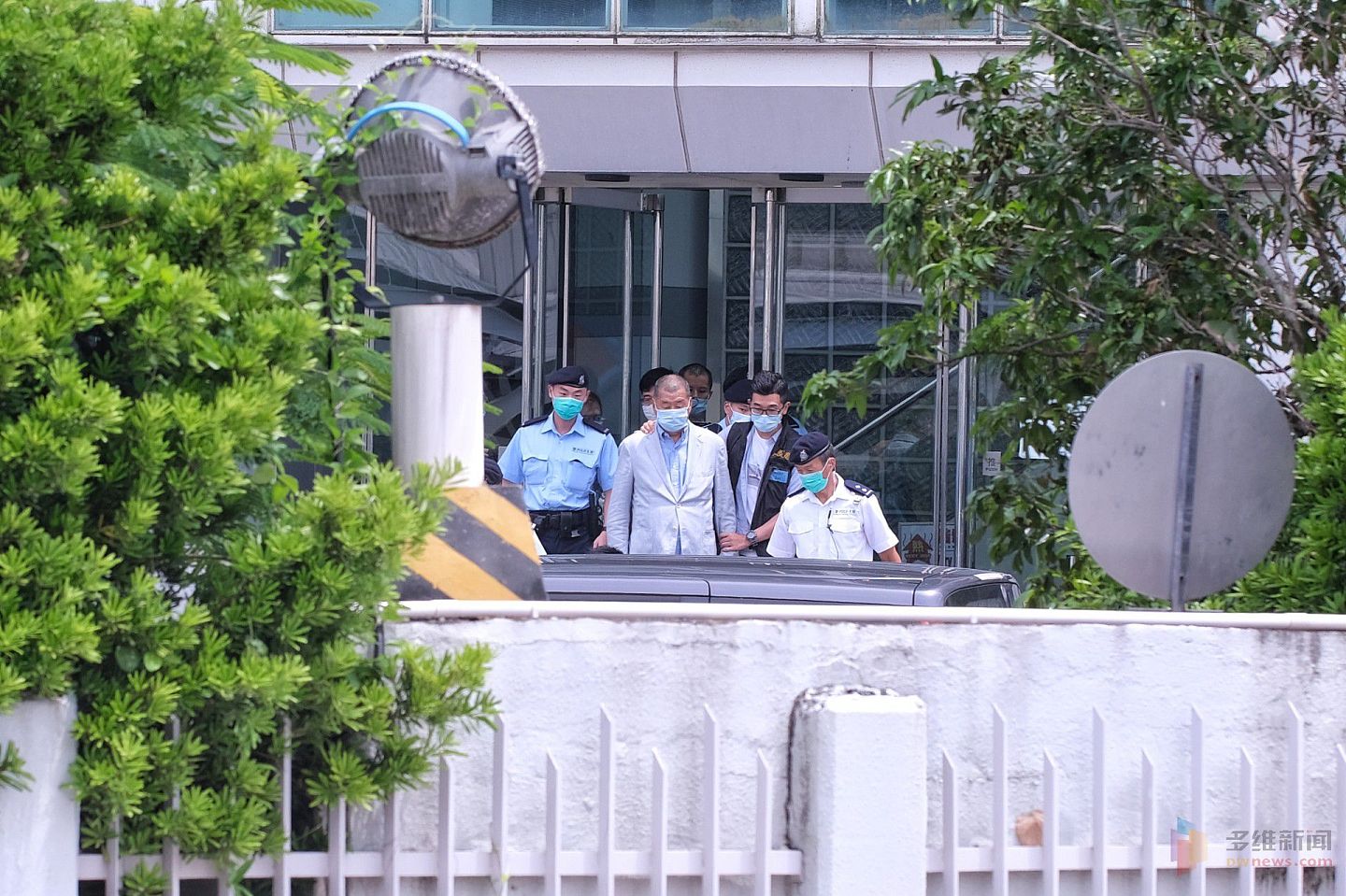 搜查3小时后，8月10日下午1时27分黎智英在警员押解下离开壹传媒大楼。（HK01）