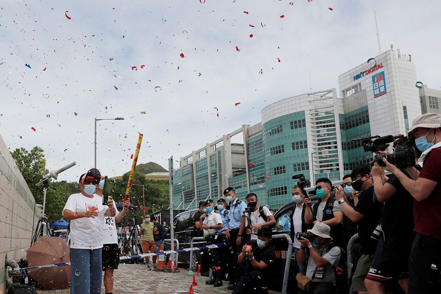 香港警方逮捕壹传媒集团创办人黎智英等10人后，一些民众在《苹果日报》大楼外庆祝。（Reuters）