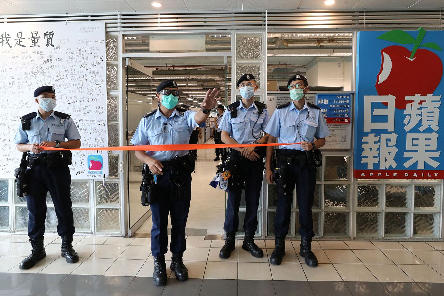 逮捕黎智英当天，香港警察戴着口罩在《苹果日报》前站岗。（Reuters）