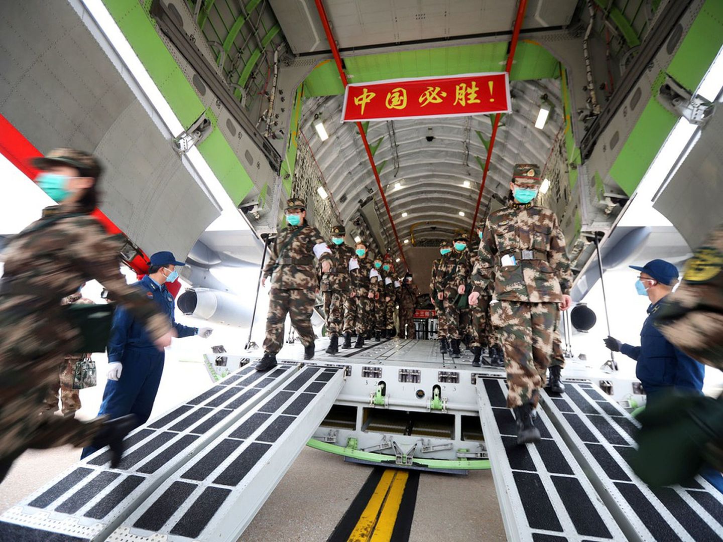 2月13日，武汉爆发新冠肺炎疫情期间，中国人民解放军医疗人员乘坐空军运输机抵达武汉天河国际机场紧急参与防疫救援。（Reuters）