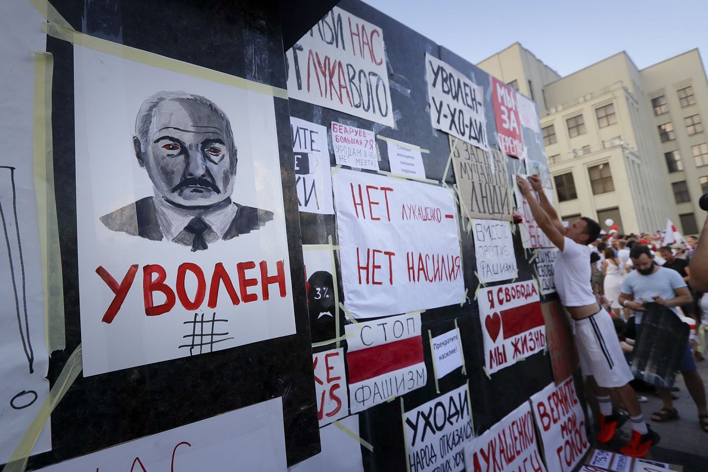 8月16日，示威人士在政府大楼贴上抗议白罗斯总统卢卡申科的海报贴。（美联社）