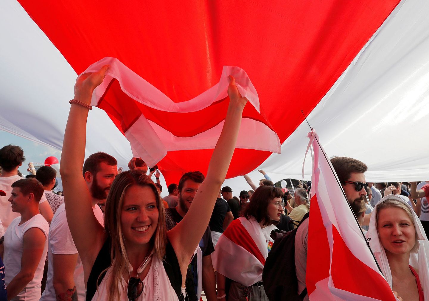 示威人士高举旧白罗斯国旗，要求总统卢卡申科辞职，并释放被拘押的示威者。（路透社）