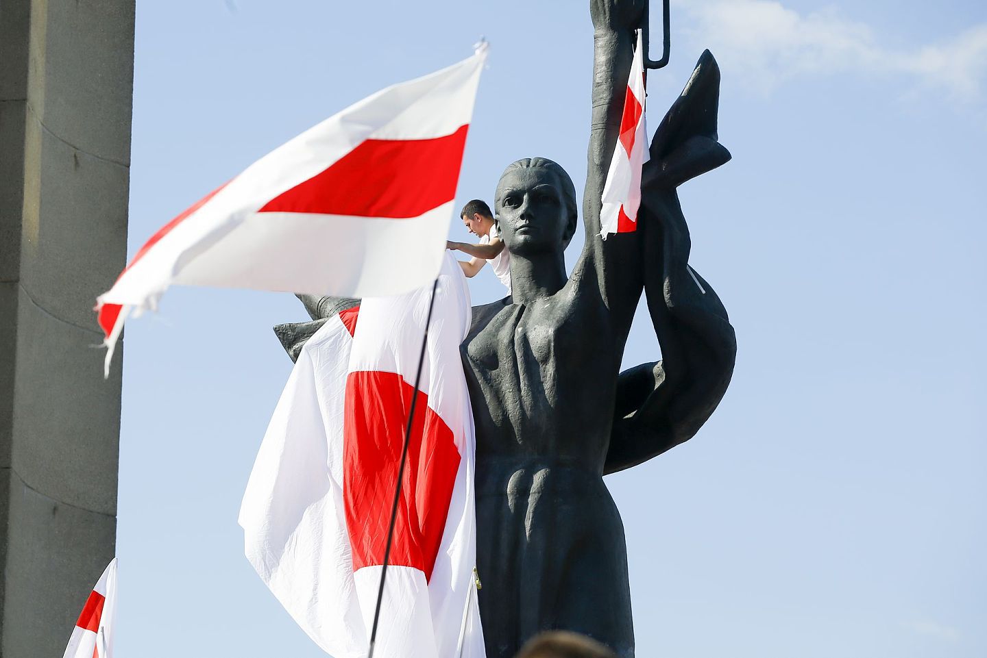 8月16日，示威人士把旧白罗斯国旗把挂在第二次世界大战反纪念雕像上。（美联社）