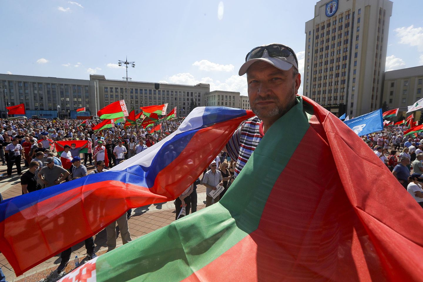 2020年8月16日，白罗斯首都明克斯，卢卡申科在独立广场举行支持者集会，有支持者用白俄罗斯国旗和俄罗斯国旗遮盖身体。（AP）