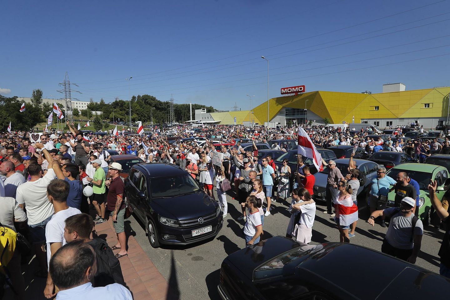 示威者举着白俄罗斯流亡当局的白红白国旗聚集在明斯克拖拉机厂，白俄罗斯总统卢卡申科在这里向员工发表讲话。（美联社）