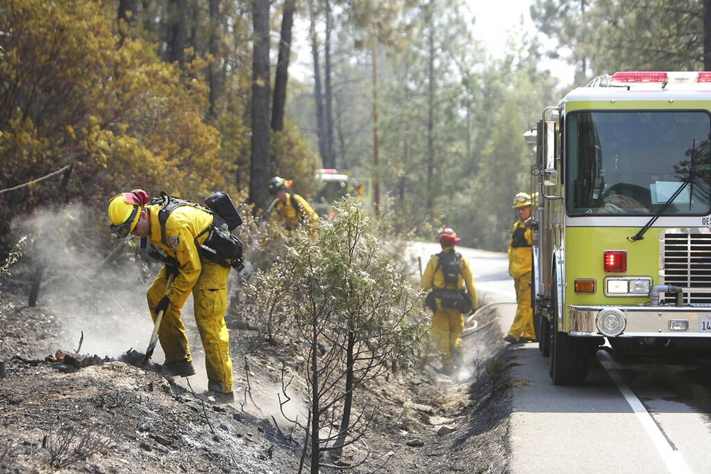图为8月18日，加州草谷市（grass valley ）消防员尽力阻止死灰复燃。 （美联社）