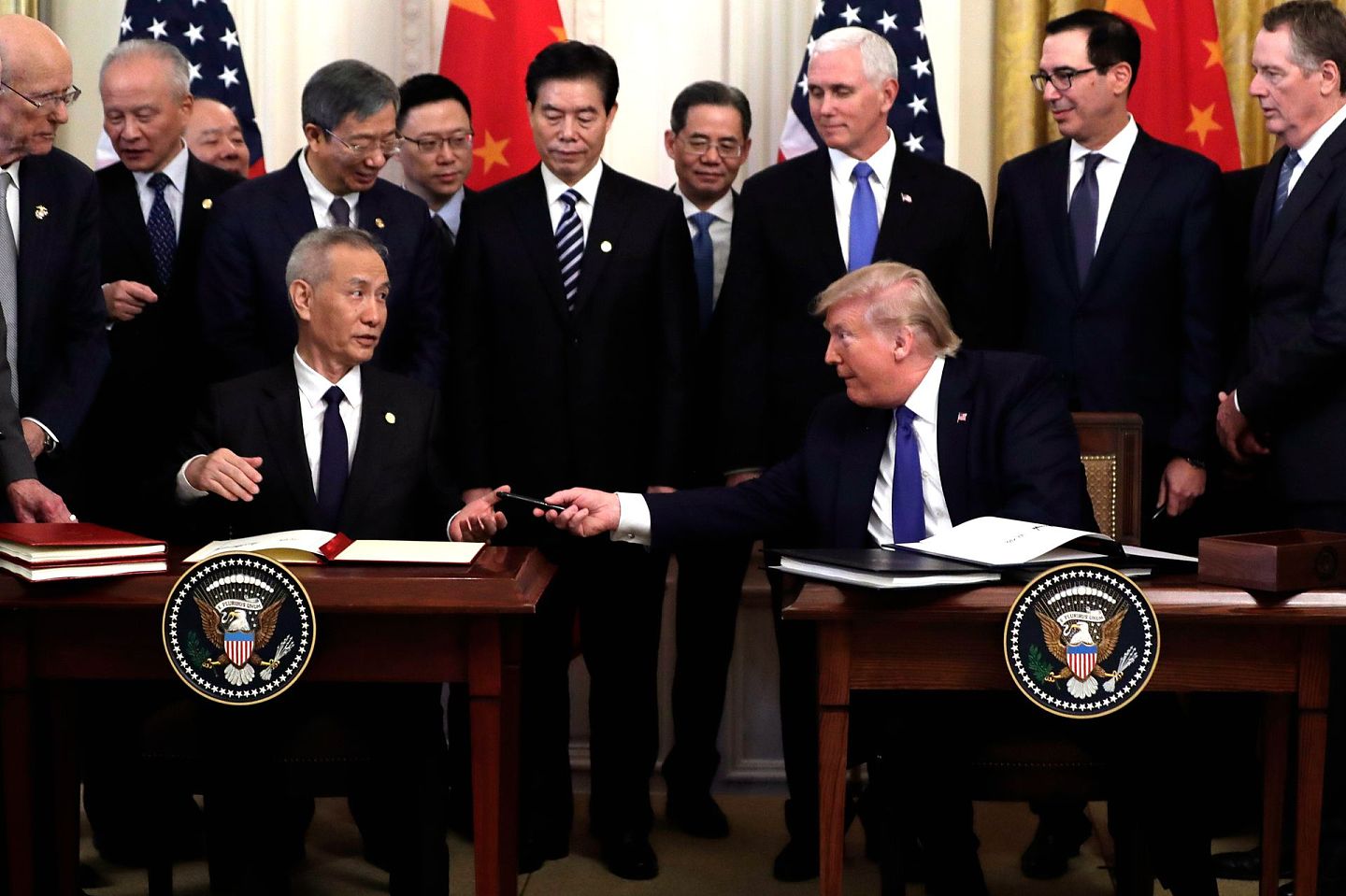 2020年1月15日，特朗普在白宫东厅与中国副总理刘鹤签署美中第一阶段贸易协定，特朗普向刘鹤递出签字用的笔。（AP）
