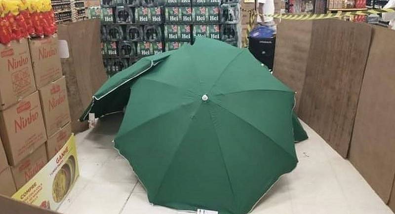 销售员猝死店内，卖场以雨伞遮蔽尸体，并以纸箱等物品隔开走道。 （图撷自推特）