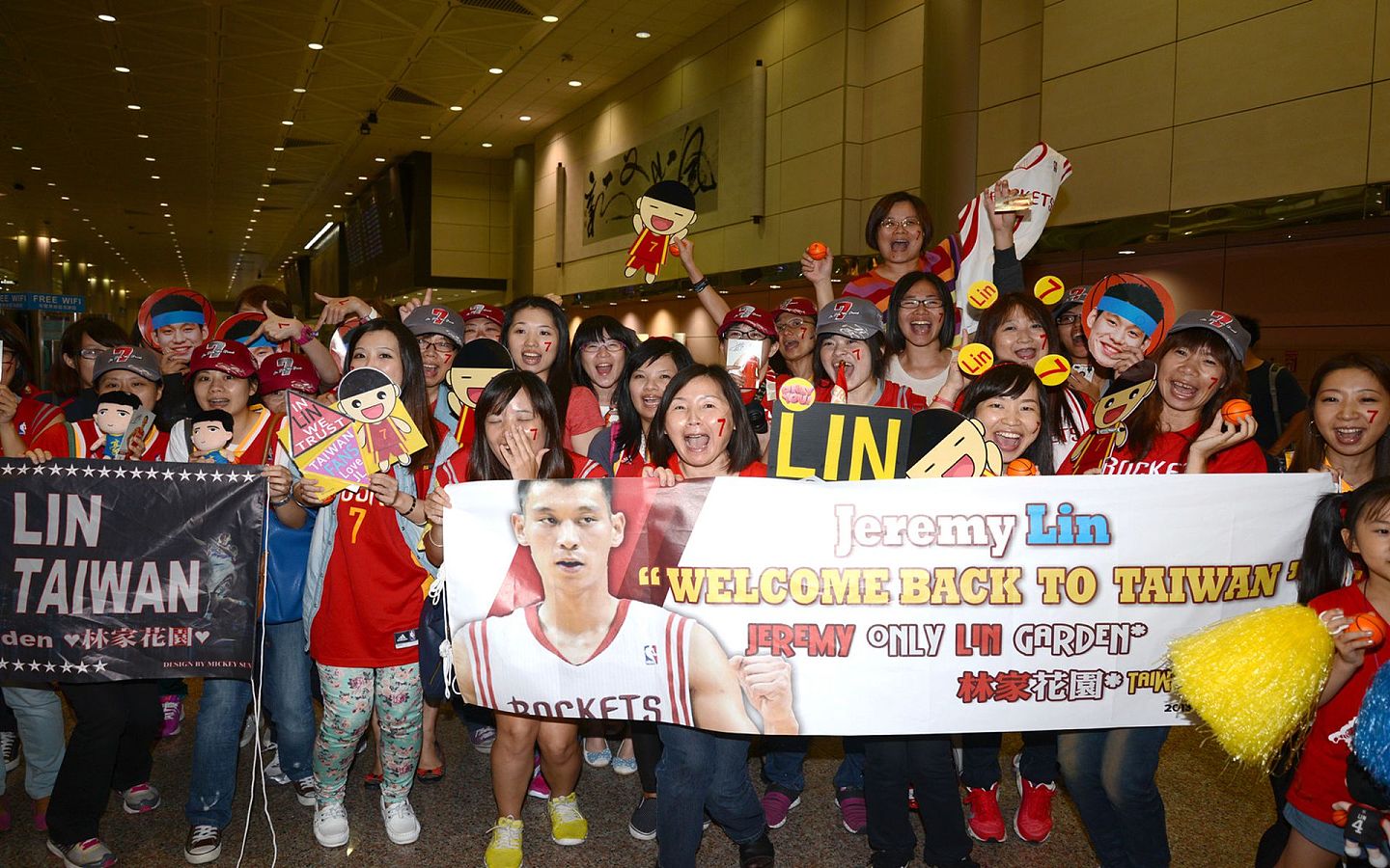 林书豪被台湾认为是台湾之光，图为林书豪于2013年搭机抵台，他在入境大厅分送球迷小篮球并与他们合影。 让凌晨就来守候的热情球迷开心大喊值得。（中央社）