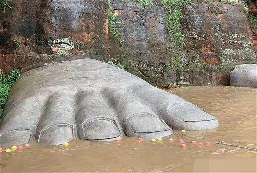 图为当地为乐山大佛的佛脚做了保护措施，以水泥完全包覆，避免被游客或洪水破坏。 （图／网易）