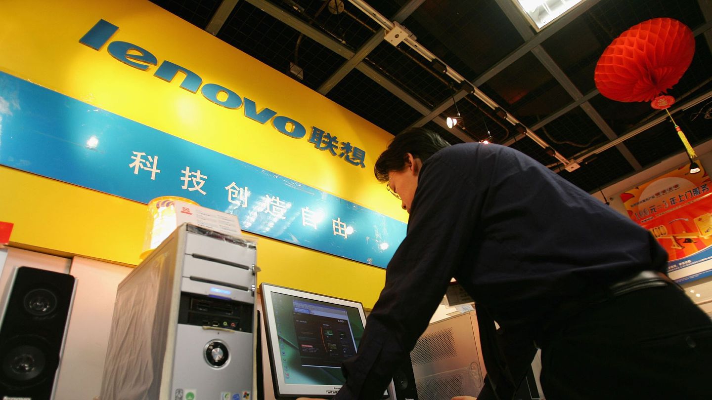 联想代工厂遭美国制裁：图为2005年1月28日，中国北京一名售货员在店中使用联想出品的电脑。（Getty）