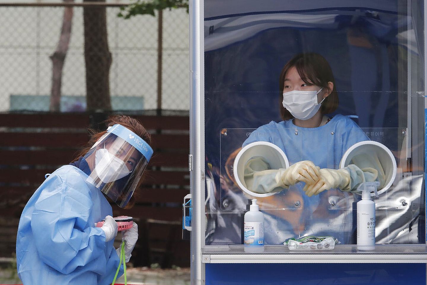 8月19日，医护人员在首尔地方警察厅一个临时建立的诊所工作。医护人员以手提风扇帮助患者散热。（AP）