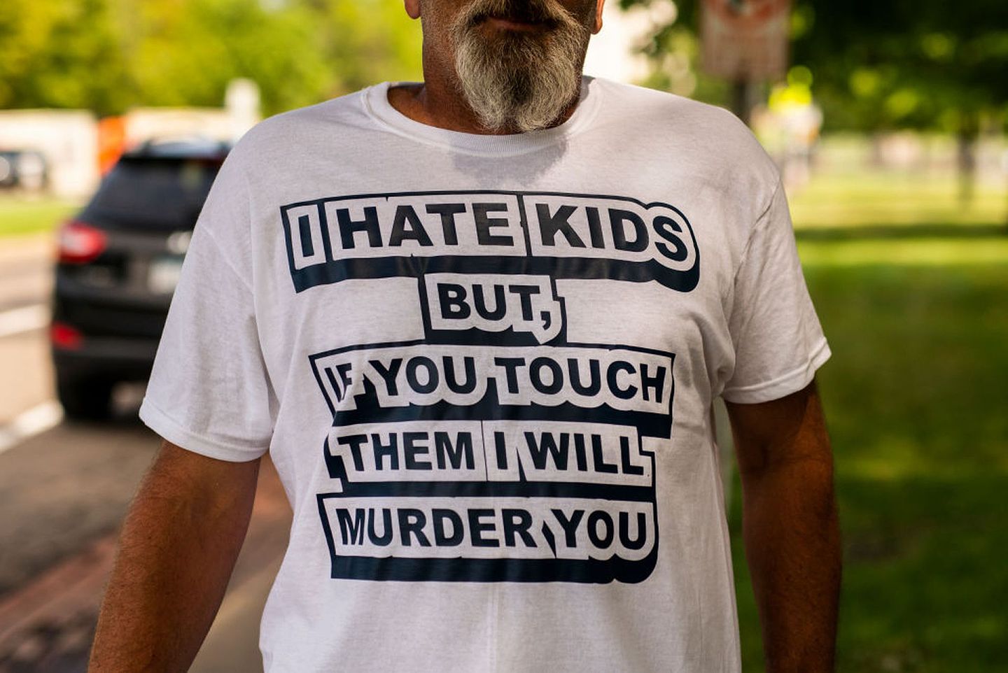 QAnon信徒穿着印有“我讨厌小孩，但如果你碰他们，我会把你杀死”的T恤。（GettyImages）