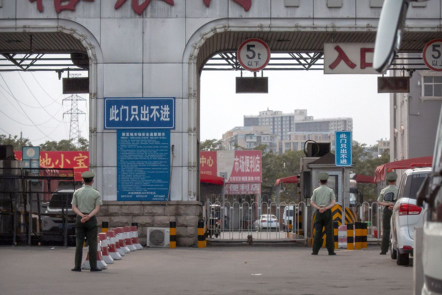 武警在新发地批发市场外戒严，大门上写有“此门只出不进”的牌子。（AP）