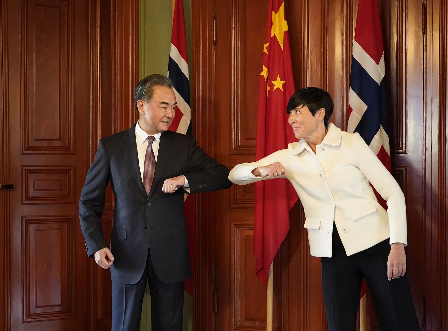 8月27日，中国国务委员兼外长王毅（左）在挪威奥斯陆同挪威外交大臣瑟雷德举行会谈前碰肘留影。（新华社）