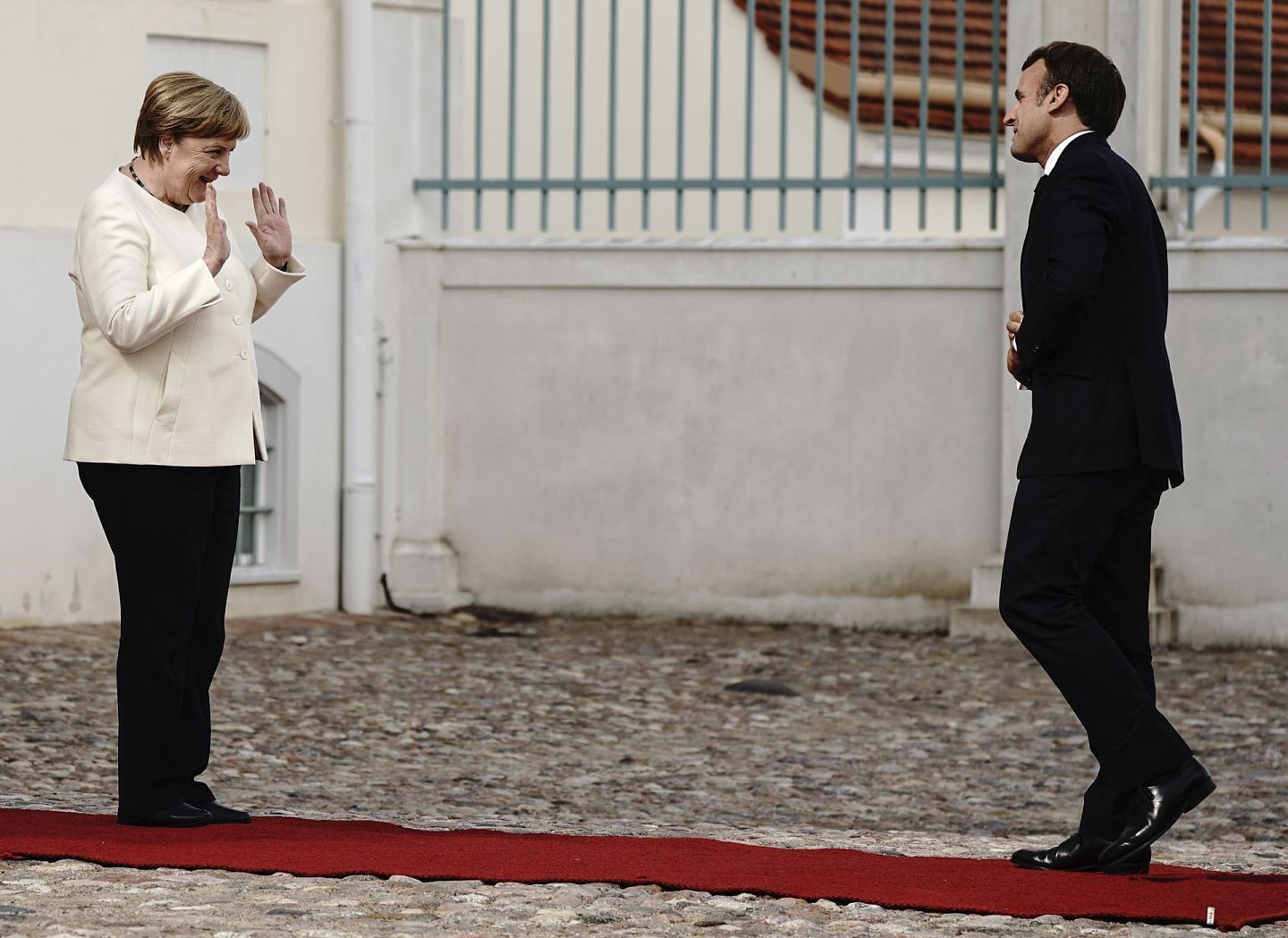 法德两国领导人在中美议题上比较谨慎，尽量避免倒向任何一方。图为2020年6月29日，德国总理默克尔（左）在梅塞伯格城堡前欢迎法国总统马克龙。（AP）