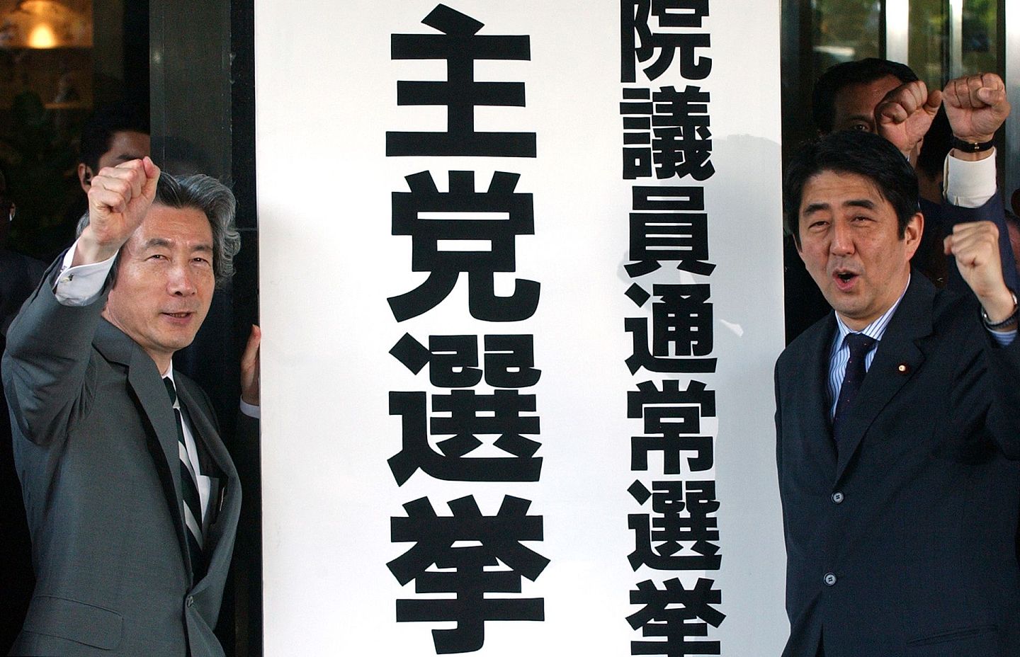 2004年6月16日，时任日本首相小泉纯一郎(左)和时任执政党自民党干事长安倍晋三(右)在东京的党总部为即将到来的上院选举设立选举中心。（AP）
