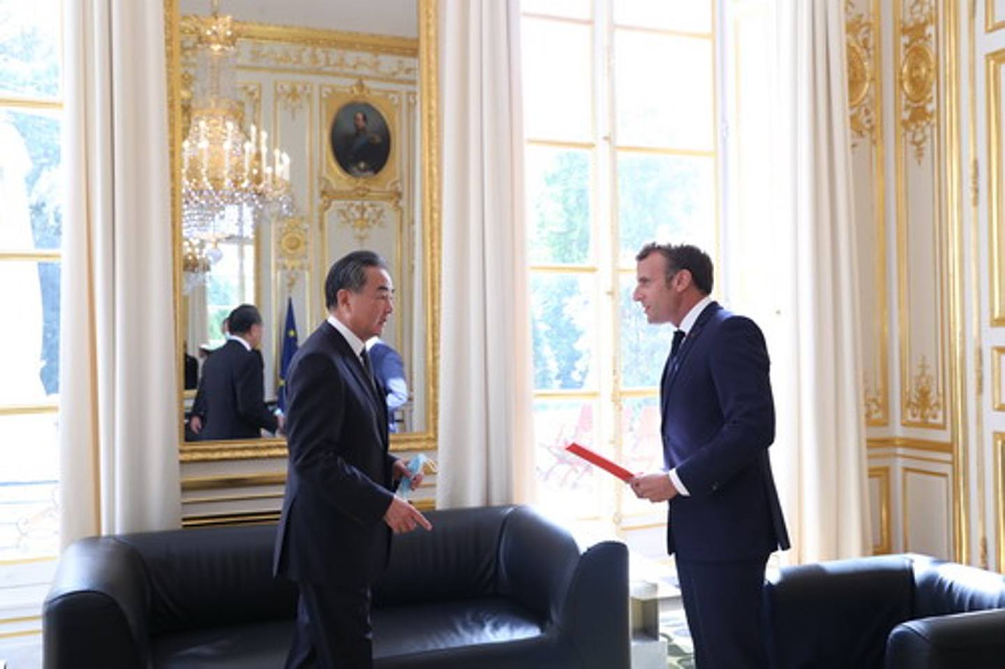 法国总统马克龙（Emmanuel Macron）8月28日在爱丽舍宫接见中国国务委员兼外交部长王毅（左）。 王毅向马克龙转达了中国国家主席习近平的口信和一本书。 （中国外交部）