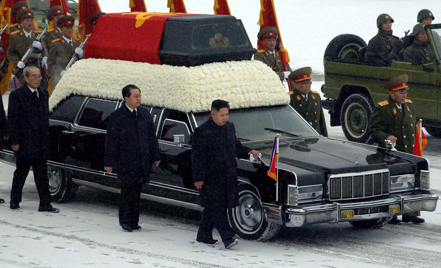 2011年金正日逝世：2011年12月28日，朝鲜举行金正日的遗体告别仪式，金正恩（中）与其他官员在灵车旁随行（美联社）