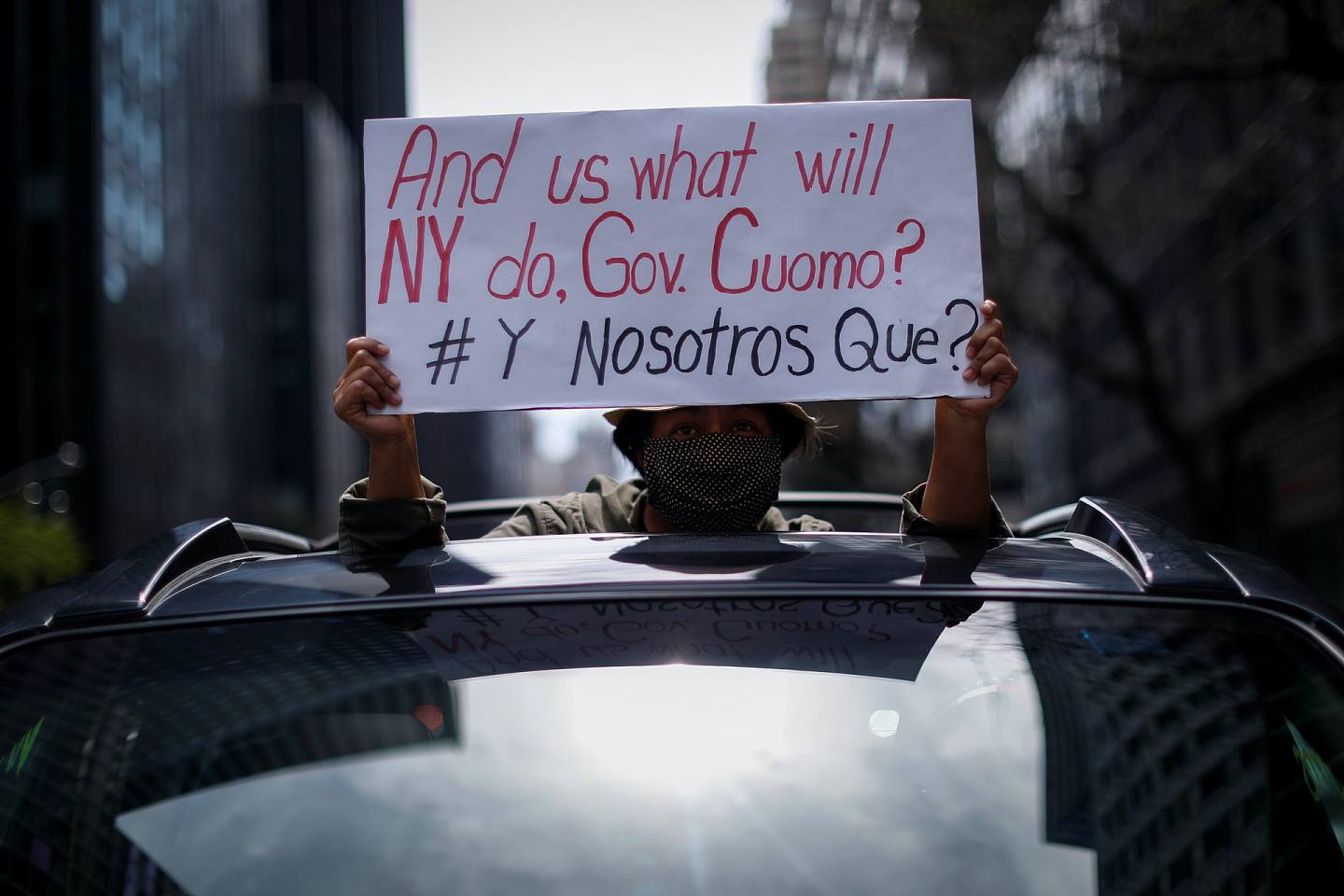 图为4月21日，美国纽约州纽约市有组织发起示威，要求保障移民劳工的权利。 有示威者手持标语。 （Reuters）