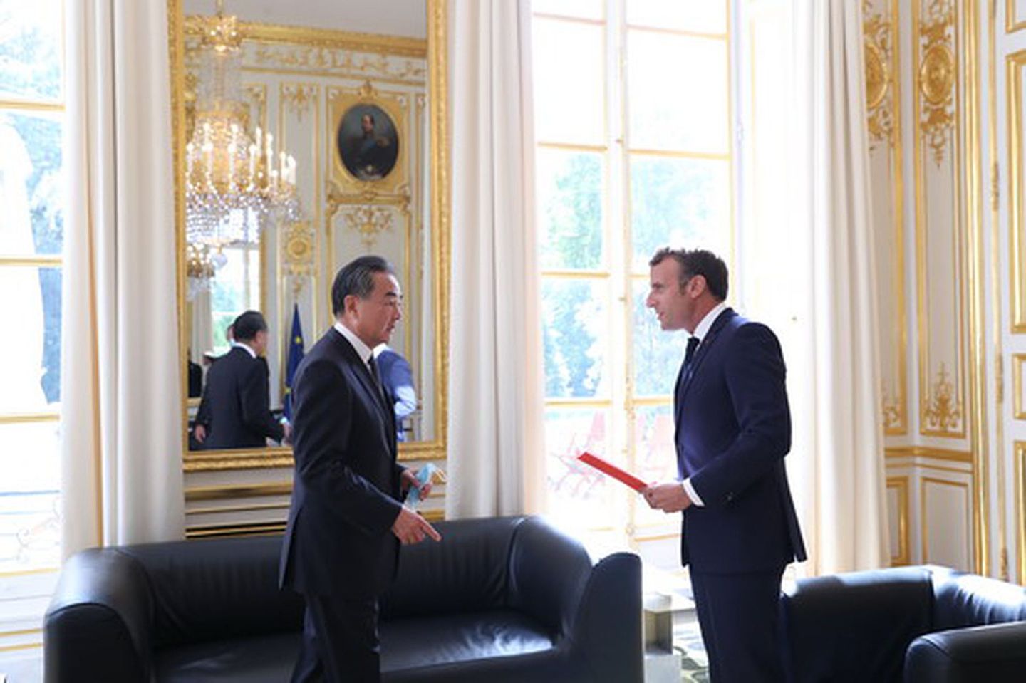 法国总统马克龙（Emmanuel Macron）8月28日在爱丽舍宫接见中国国务委员兼外交部长王毅（左）。王毅向马克龙转达了中国国家主席习近平的口信和一本书。（中国外交部）