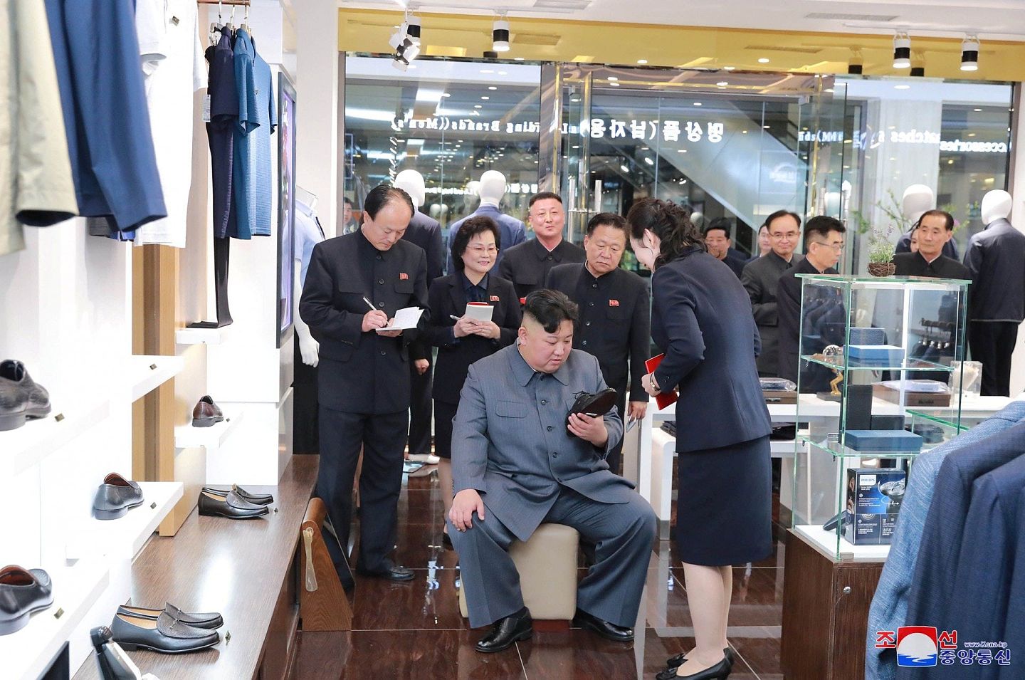朝中社2019年4月8日发布金正恩视察平壤大城百货的照片，图为他在细看一只鞋，金与正在一旁陪同。 （Reuters）