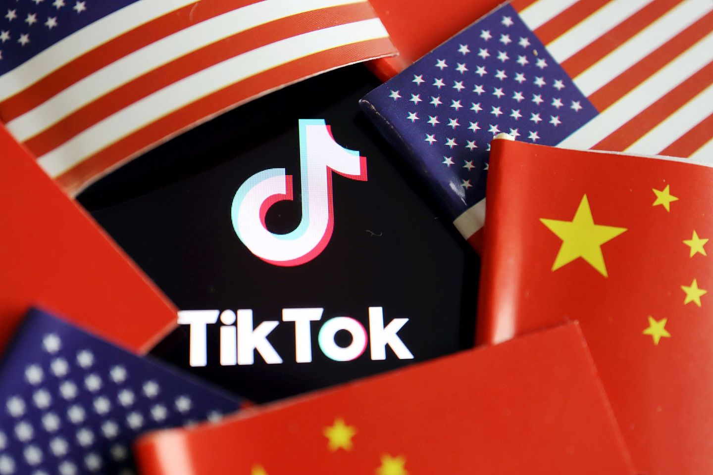 图为7月16日TikTok的标志被中国及美国的国旗包围。 （Reuters）