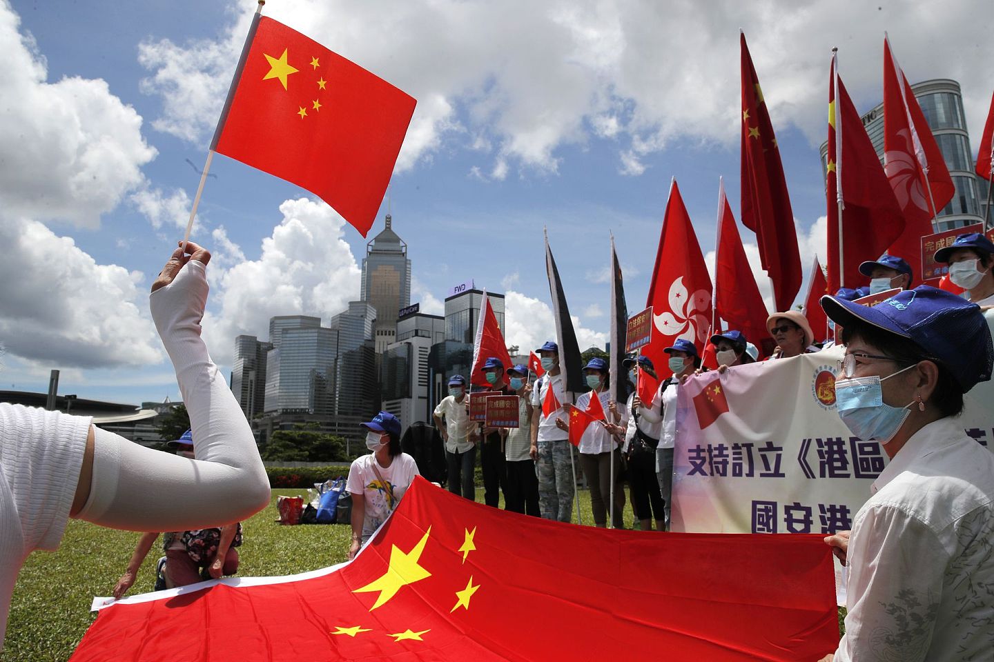 “港版国安法”在香港得到多方支持。2020年6月30日，支持者在庆祝“港版国安法”通过的集会上举着国旗。（AP）