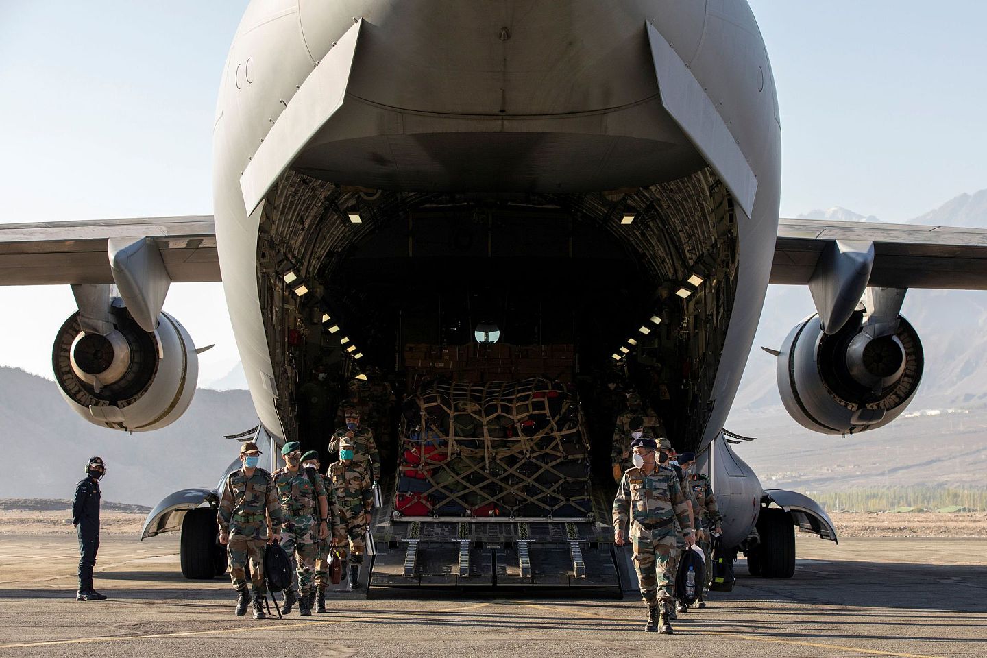 印军从一架运输机上走下来，身后有大量军用物资。（Reuters）