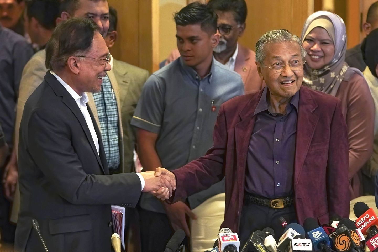 颇具讽刺意味的是，就在马哈蒂尔退盟逼宫前两天，马哈蒂尔（前排右）还在马来西亚布城与原定继任者安瓦尔（前排左）握手，劝对方“他必须有耐心”。 （美联社）