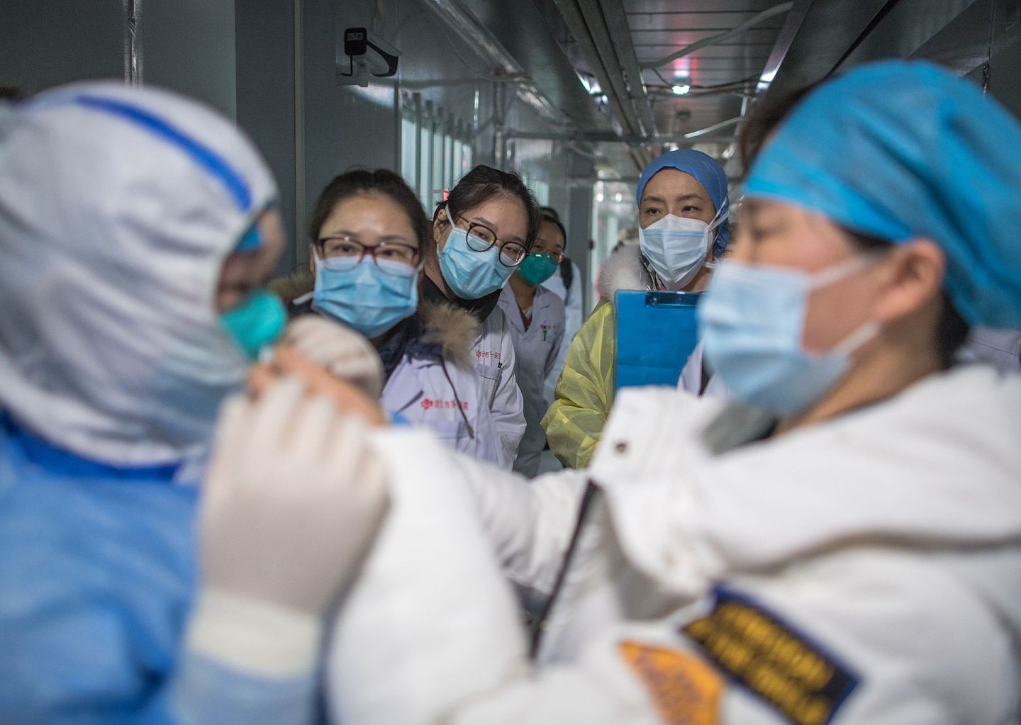 2020年2月8日，武汉雷神山医院护士观看示范防护服的穿戴。（新华社）
