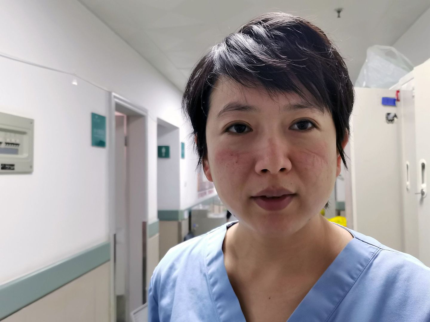 2020年2月5日，一名护士走出武汉大学中南医院重症医学科隔离病房后，摘下防护设备，面部可见明显的印痕。（新华社）