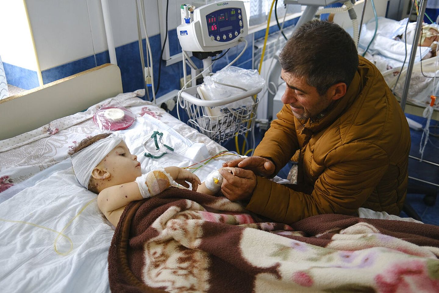 阿塞拜疆与亚美尼亚：亚美尼亚与阿塞拜疆冲突导致有平民伤亡。图为9月28日，一名男子在纳戈尔诺—卡拉巴赫地区一间医院与他的孩子讲话，这名孩子在冲突中受伤。（AP）