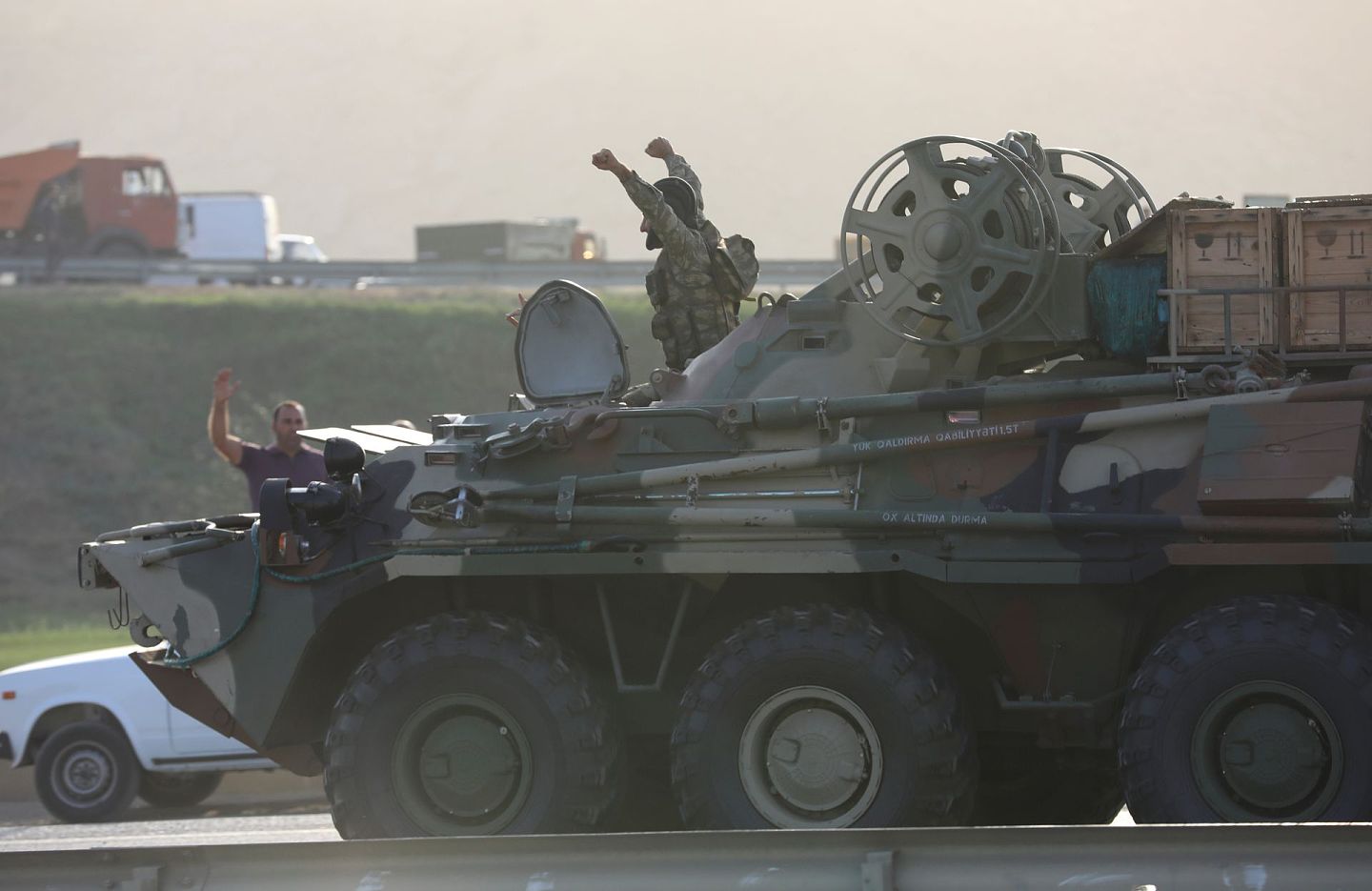 9月27日，阿塞拜疆巴库一名军人在装甲车上高举双臂，向聚集在路边的民众打招呼。（AP）