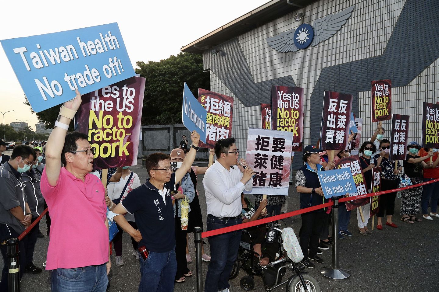 当地时间9月17日傍晚，美国国务院次卿克拉奇搭专机抵达台湾，国民党立委赖士葆（前左二）、费鸿泰（前左）等人下午赴台北松山机场外，举牌抗议瘦肉精美猪进口台湾。 （中央社）