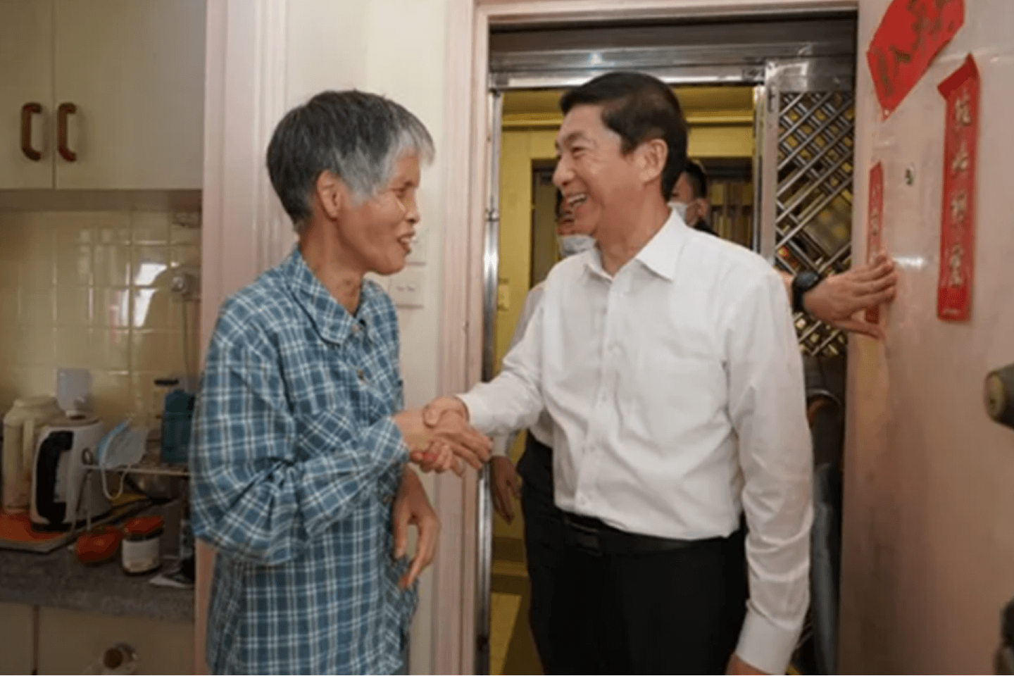 骆惠宁（右）与曾捐款支持抗疫工作的港民握手。 （香港中联办官网）