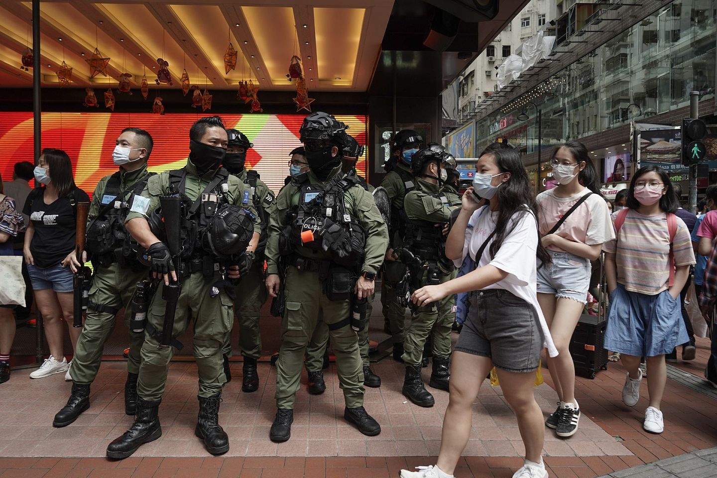 2020年10月1日，行人经过在铜锣湾站岗的香港警察。 （AP）