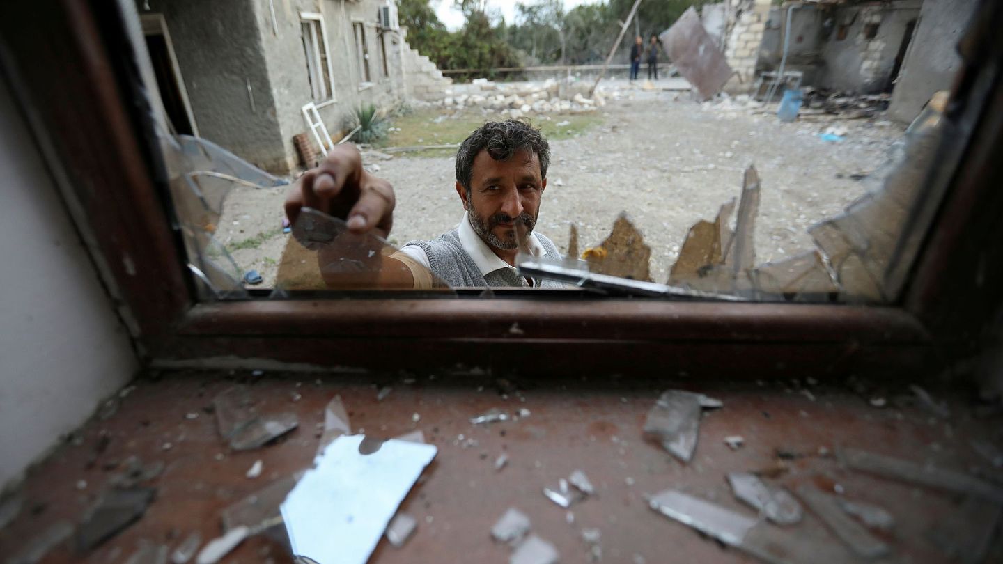 阿塞拜疆与亚美尼亚：图为2020年10月4日，阿塞拜疆一间房屋在袭击中受损，民众清理窗户的玻璃碎。 （Reuters）