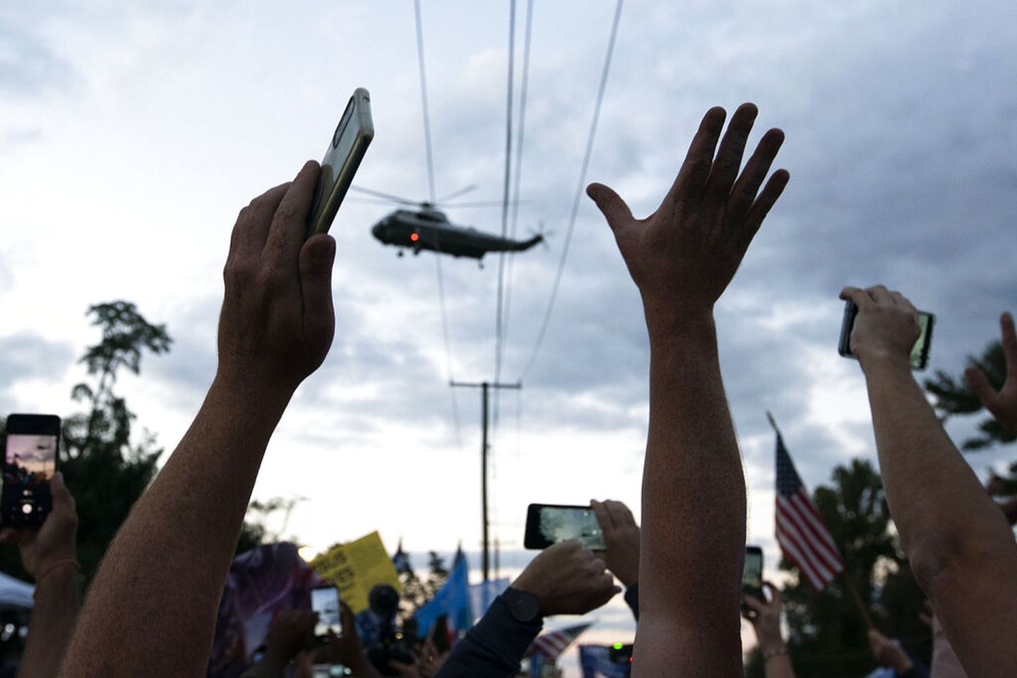 特朗普5日乘直升机从医院返回白宫，他的支持者拍照欢呼。（美联社）