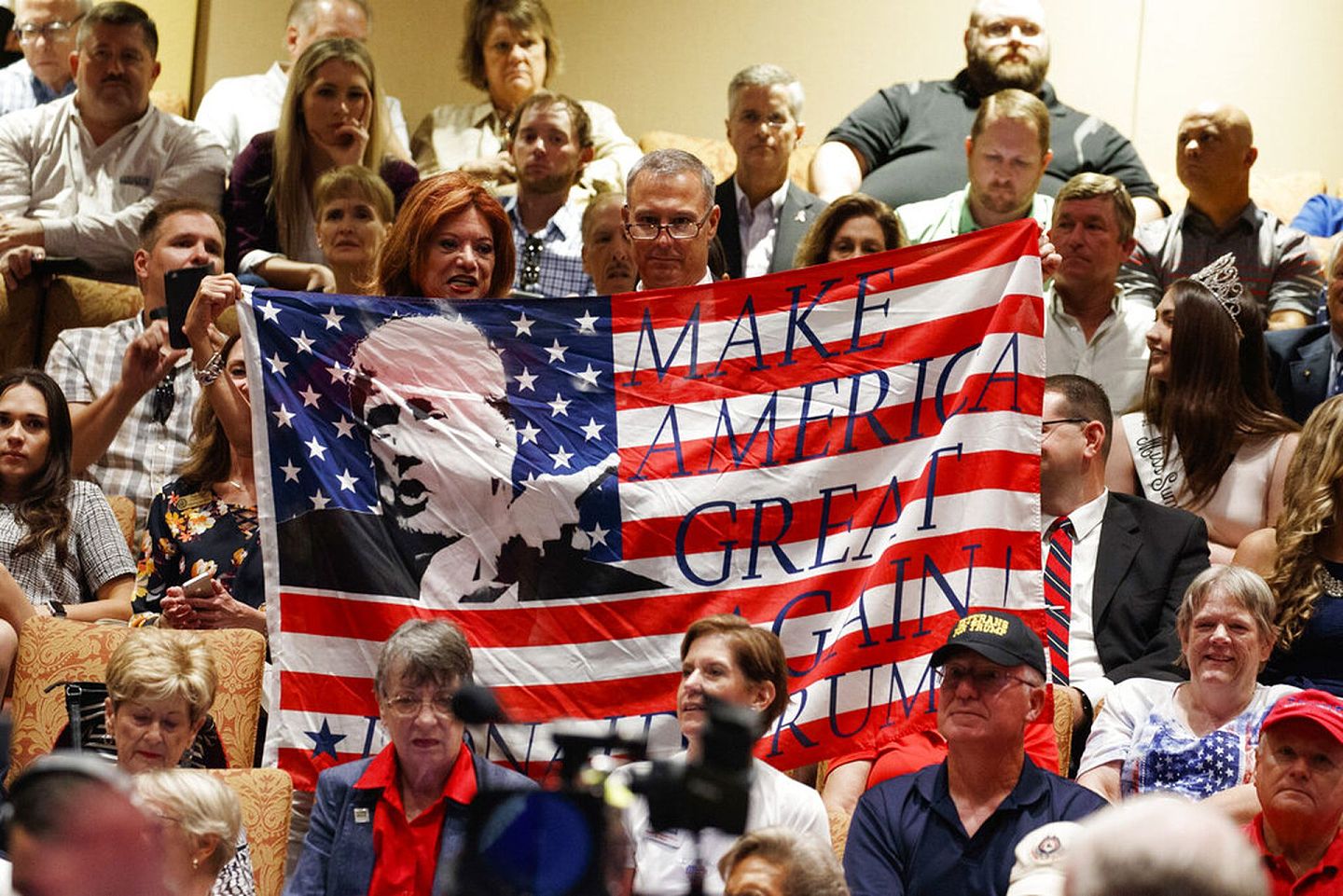 特朗普的支持者举着印有特朗普的竞选口号“让美国再次伟大”的旗帜。（AP）
