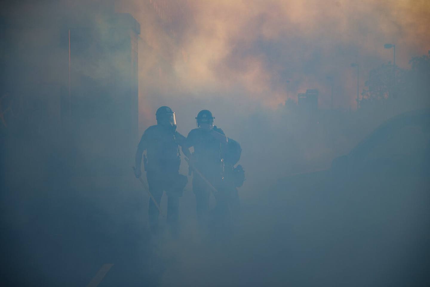 美國明尼蘇達州示威：圖為5月28日明尼蘇達州聖保羅市的警員執勤時穿過催淚氣體的煙霧。（AP）