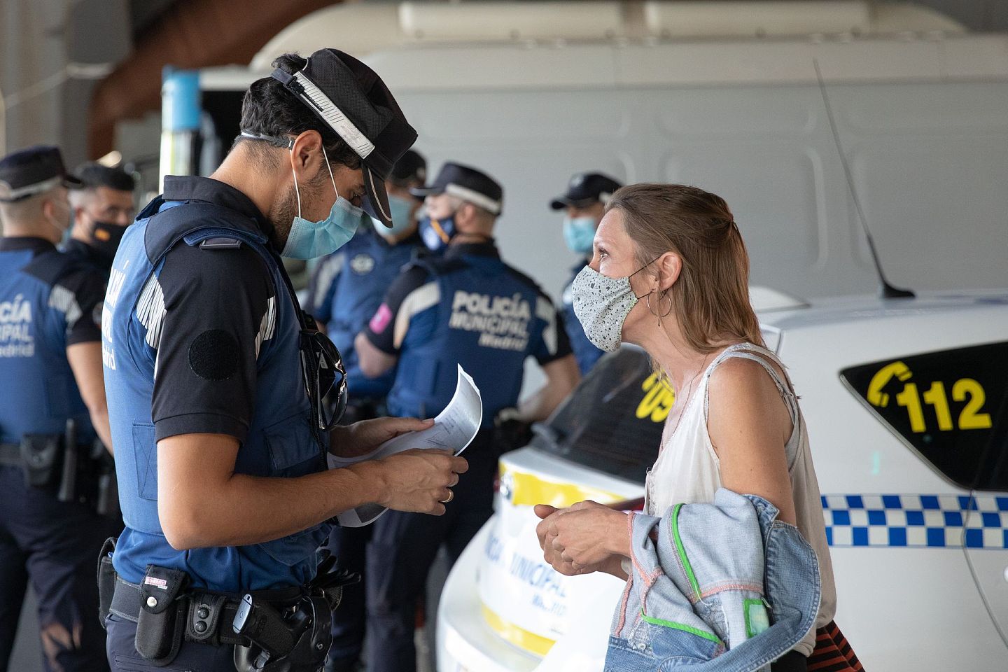 9月21日，在西班牙马德里瓦拉卡斯桥区，警察检查过往行人的出行目的。 （ 新华社）