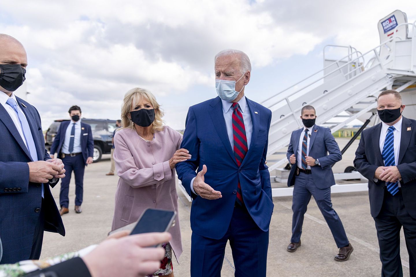 拜登的选情持续看好。图为2020年10月5日，吉尔·拜登（Jill Biden）将她的丈夫、民主党总统候选人、前副总统拜登从媒体记者的围堵中带回来，当时拜登正在特拉华州的纽卡斯尔机场（New Castle Airport）的飞机外发表讲话。（AP）