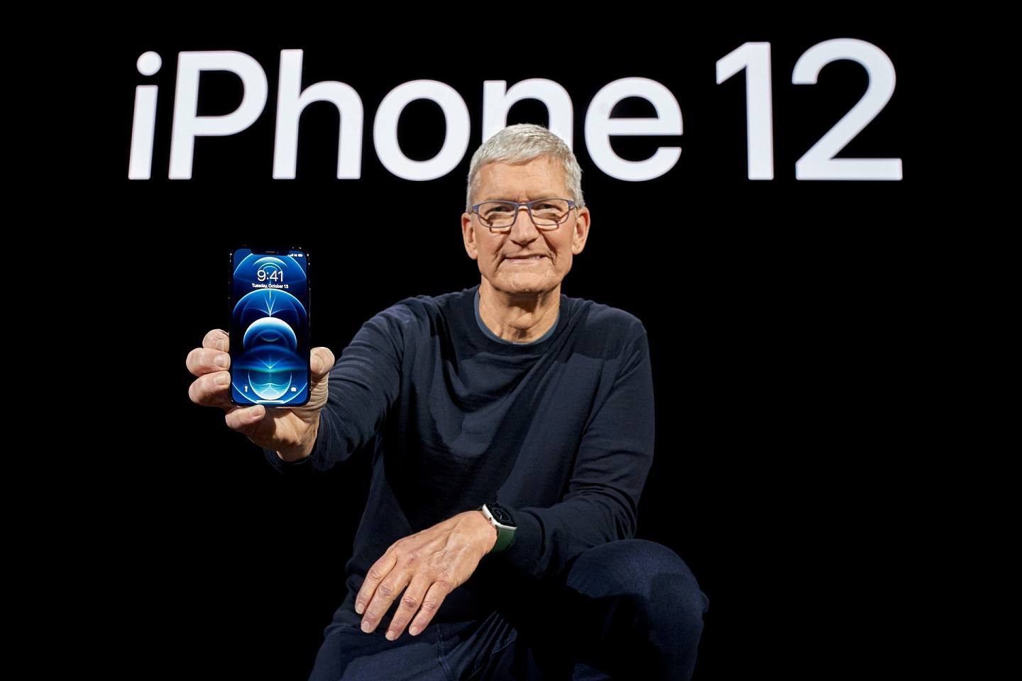 图为10月13日美国iPhone 12发布会，行政总统库克（Tim Cook）手上拿着最新款iPhone。 （Reuters）