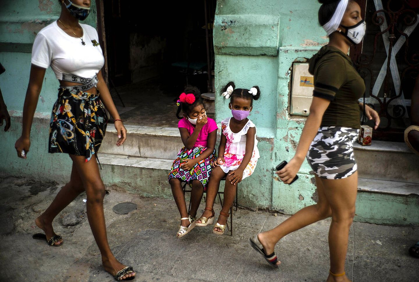 10月12日，古巴哈瓦那街头，行人戴着口罩经过。（AP）