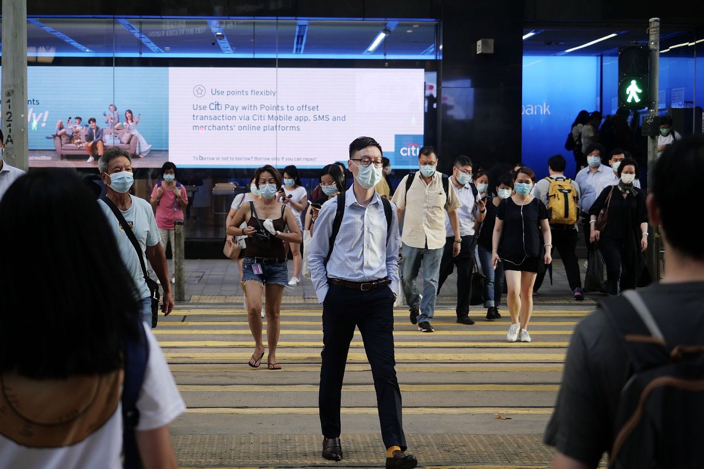 香港长时间面临着新冠肺炎疫情反弹的压力。图为香港市民在中环佩戴口罩出行。（新华社）