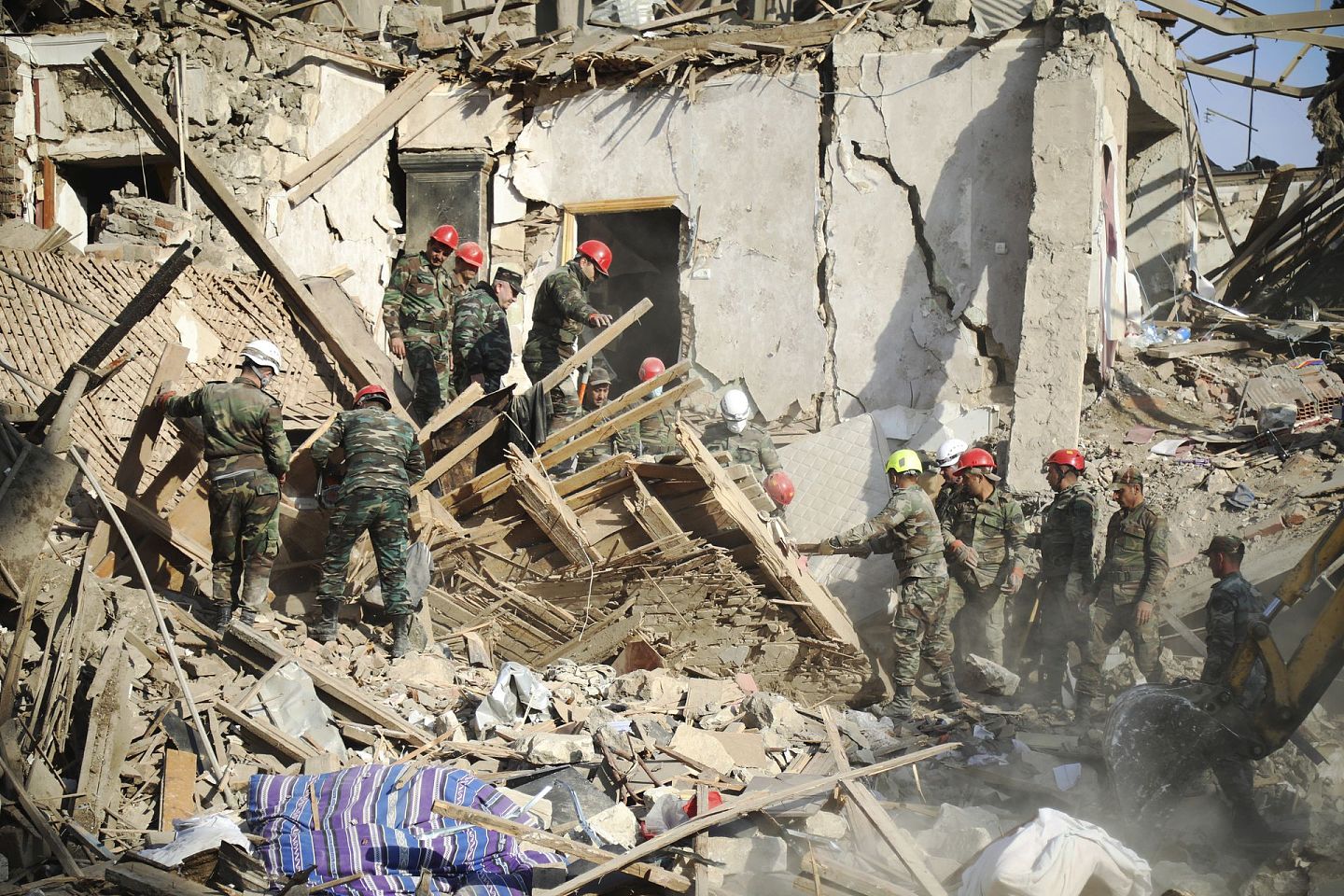 2020年10月11日，救援人员在阿塞拜疆第二大城市甘贾的废墟中执行搜救清理任务。 当天，甘贾遭到亚美尼亚军方的火箭弹袭击。 （AP）