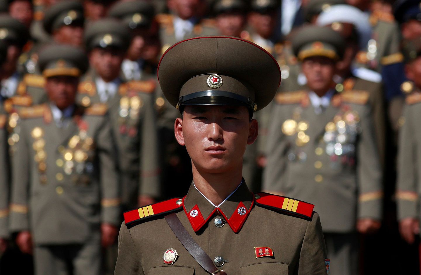 9月9日，在朝鲜首都平壤举行的纪念朝鲜建国70周年阅兵式上，一名士兵佩戴着印有已故朝鲜领导人金日成和金正日肖像的徽章。（Reuters）