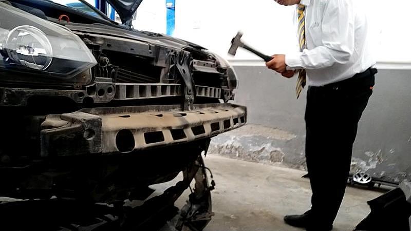 9月24日下午，上汽大众北京恒星天诚4S店的一名员工，在一辆送修汽车拆解定损前，将原本完好的水箱框架砸坏。来源：新京报调查组