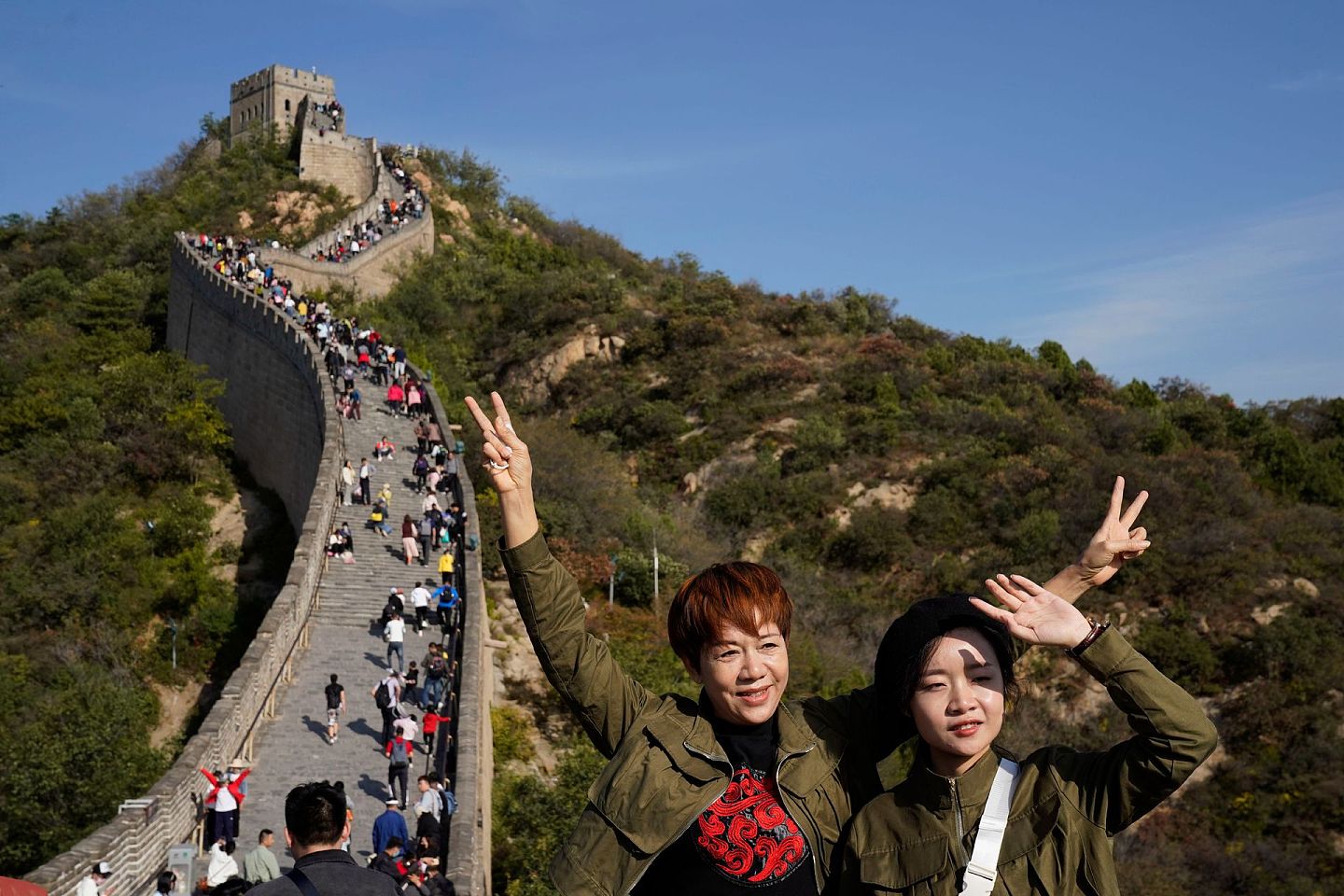 中国今年的国庆节恰逢中秋节，8天的假期是中国疫情后首个长假，大量游客外出旅游。图为2020年10月6日，游客们在北京郊区的八达岭长城上拍照。（AP）